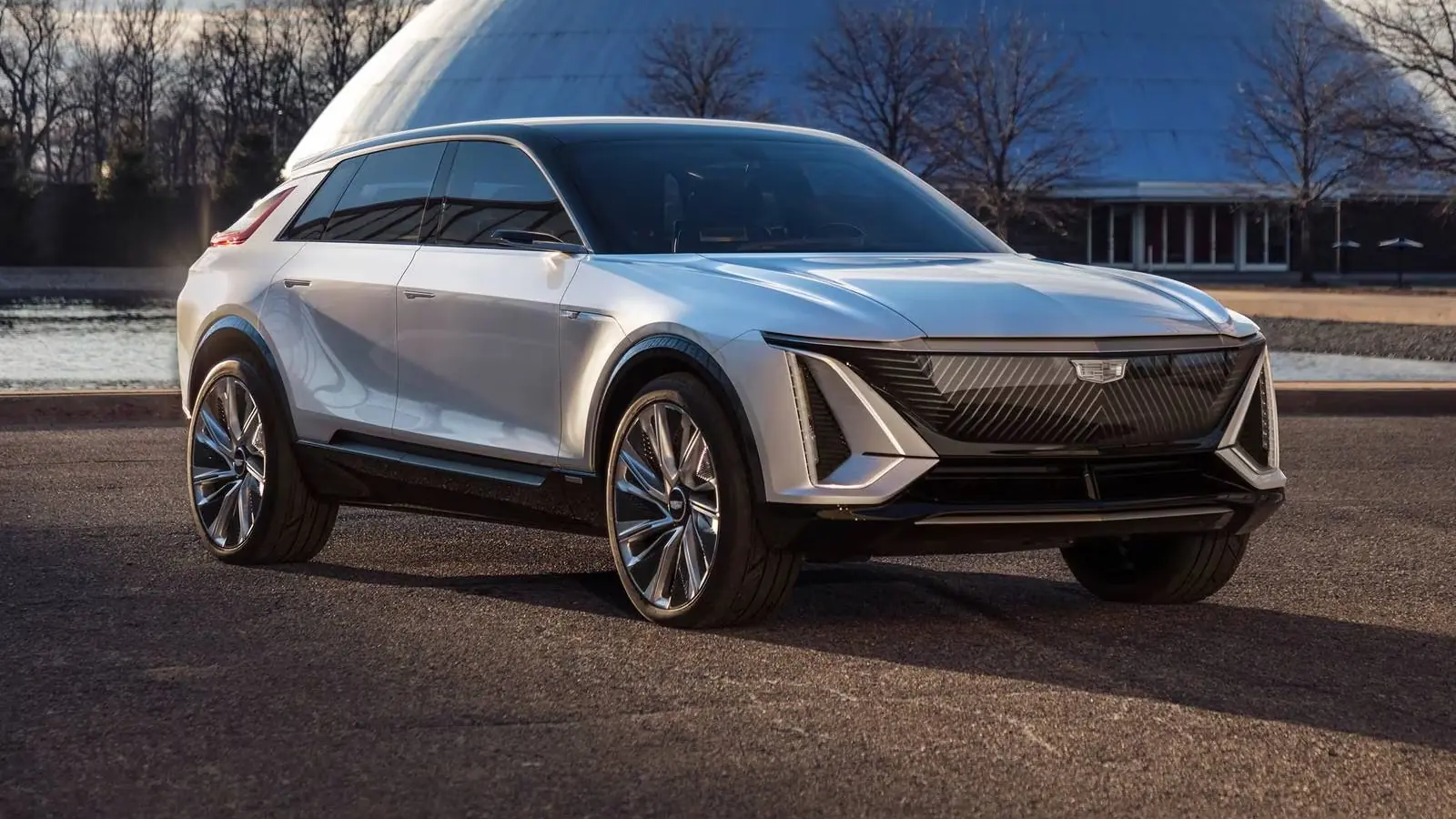 Silver Cadillac Lyriq electric SUV parked in front of GM's domed design auditorium