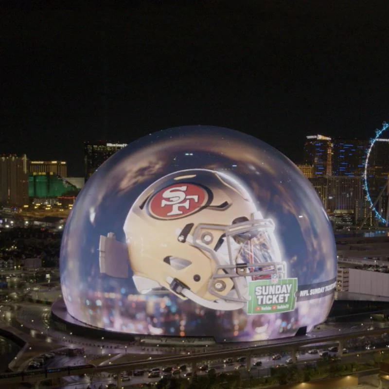 The Las Vegas Sphere showing a San Francisco 49ers helmet and the NFL Sunday Ticket logo
